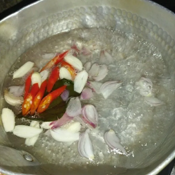 Rebus air hingga mendidih, lalu masukkan bawang merah, bawang putih, cabe merah dan daun salam, masak hingga bumbu harum.