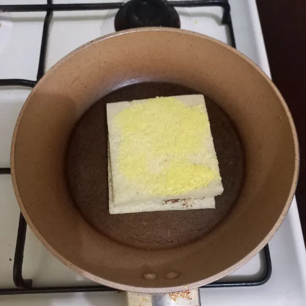 Tutup kembali dengan roti yang atasnya diolesi margarin dan gula pasir, panggang hingga kedua sisi kecokelatan.