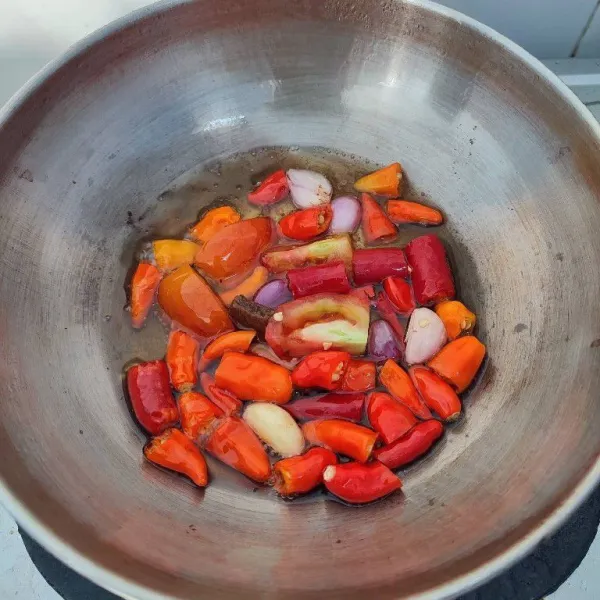 Potong cabe merah, tomat merah, bawang merah dan bawang putih. Kemudian goreng hingga layu di minyak panas. Tiriskan.