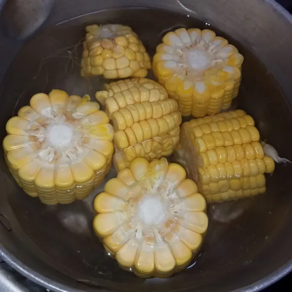 Rebus air hingga mendidih kemudian masukkan jagung masak hingga jagung matang.