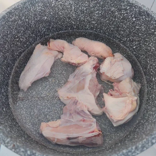 Rebus ayam kampung hingga mendidih dan keluar kotorannya, buang airnya dan cuci bersih kembali ayam.