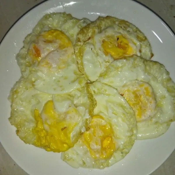 Siapkan telur yang sudah diceplok, lalu tata di piring saji.