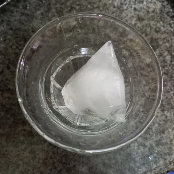 Siapkan gelas dan masukkan es batu ke dalamnya.