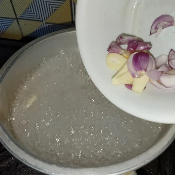 Rebus air dan masukkan irisan bawang merah dan bawang putih.