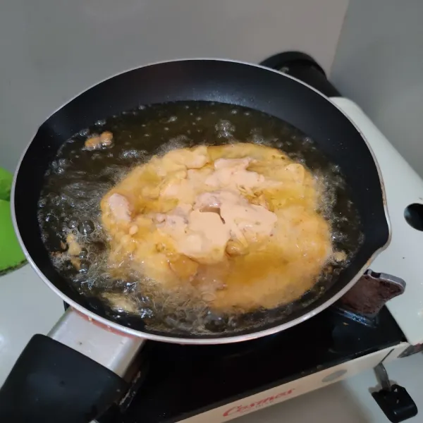 Keluarkan ayam dari bahan marinasi, celupkan ke tepung basah, kemudian goreng hingga kecokelatan.