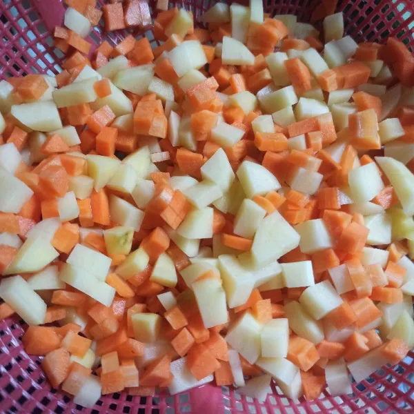 Kupas kentang dan wortel, potong kecil-kecil kemudian cuci sampai bersih.