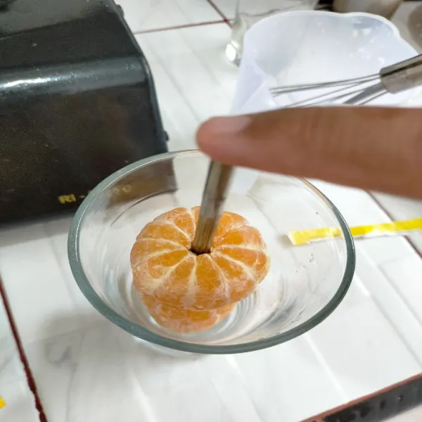 Taruh jeruk yang ditusuk sumpit dalam gelas.