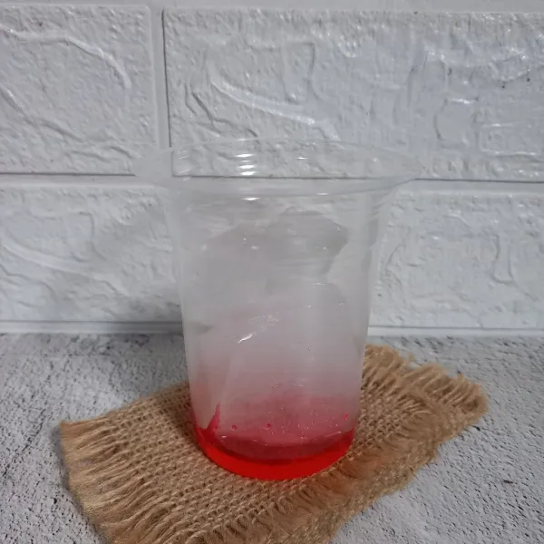 Siapkan cup atau gelas. Tuang 2 sdm sirup coco pandan dan secukupnya es batu.