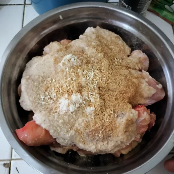 Tuang bumbu halus ke dalam ayam yang sudah dicuci bersih, tambahkan garam, kaldu jamur, dan lada.