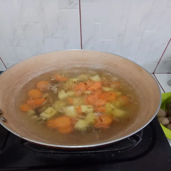 Lalu masukkan air, tambahkan wortel dan kentang lalu masak hingga matang.