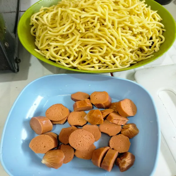 Masak mie kuning hingga matang lalu tiriskan, potong sosis.