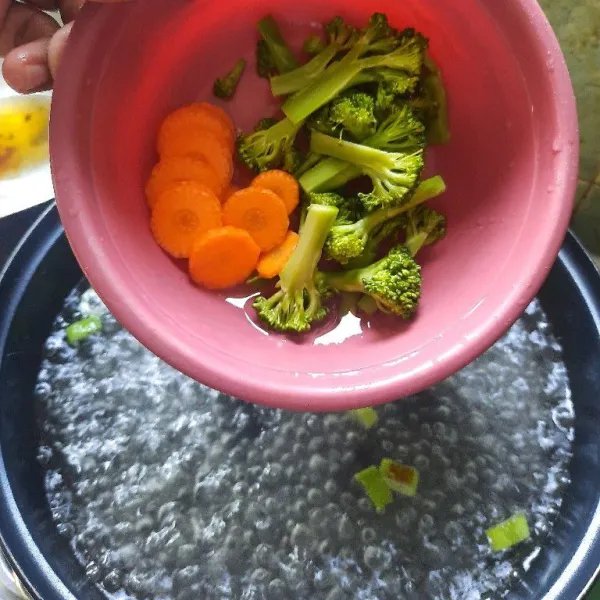 Masak air sampai mendidih lalu masukkan brokoli dan wortel, masak sampai matang.