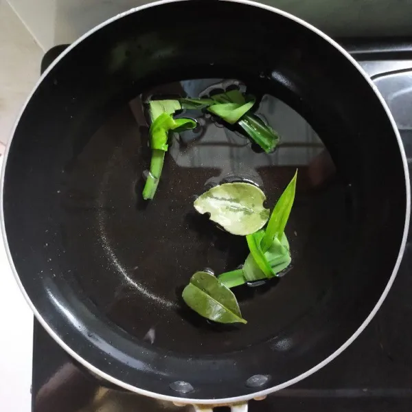 Siapkan panci, lalu tambahkan daun pandan dan daun jeruk.