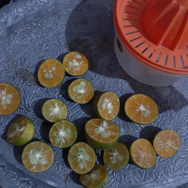 Cuci bersih jeruk kunci lalu belah dua, peras kemudian sisihkan.