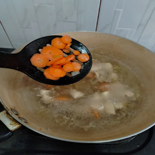 Masukkan wortel dan kaldu blok, masak hingga wortel matang.