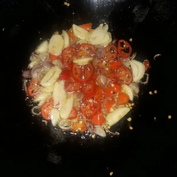 Panaskan minyak, tumis bawang merah, bawang putih, cabe rawit dan cabe merah besar sampai layu dan harum.