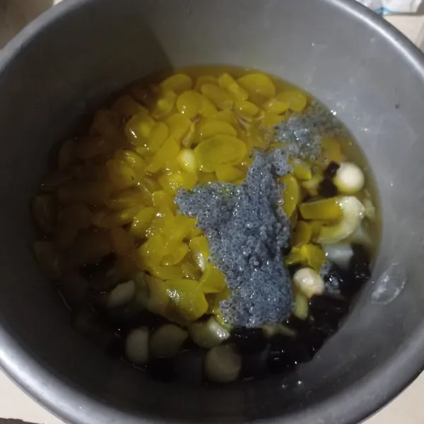 Potong kolang kaling, melon dan cincau hitam, pindahkan ke wadah lalu tambahkan nata de coco dan selasih.