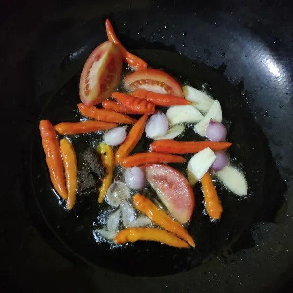 Cuci bersih cabe, tomat merah dan bawang putih, bawang merah lalu goreng bersama terasi selama 5 menit atau hingga matang.