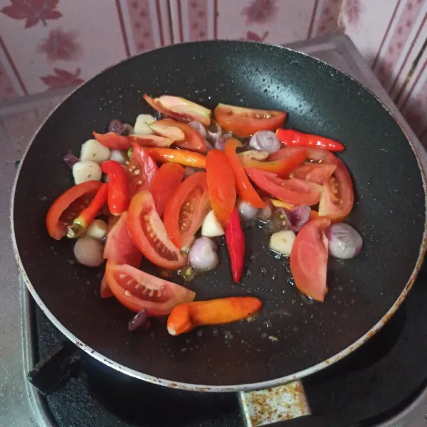 Goreng bawang merah dan bawang putih sampai layu, setelah itu masukkan cabai merah, tomat merah dan terasi, goreng sampai matang.