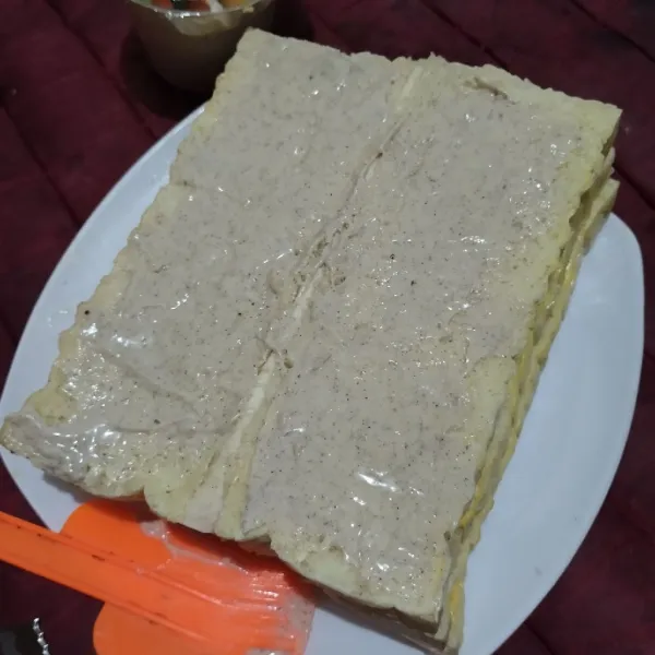 Buka satu bagian roti bandung, baluri dengan selai tiramisu.