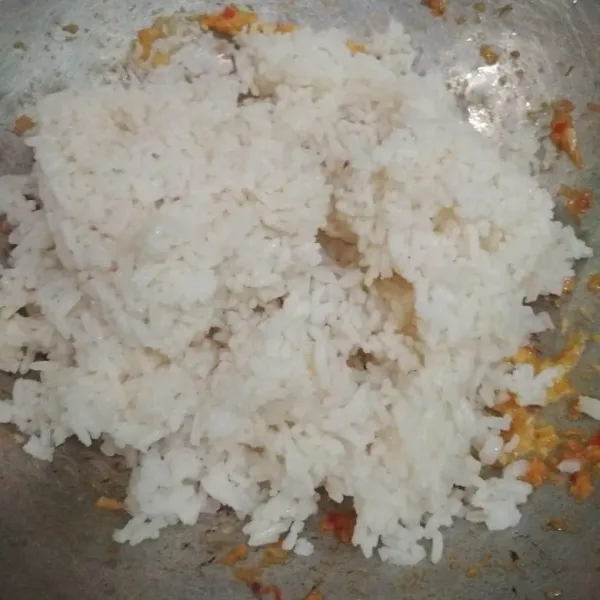 Tambahkan nasi dan kaldu bubuk, aduk hingga tercampur rata, koreksi rasa.