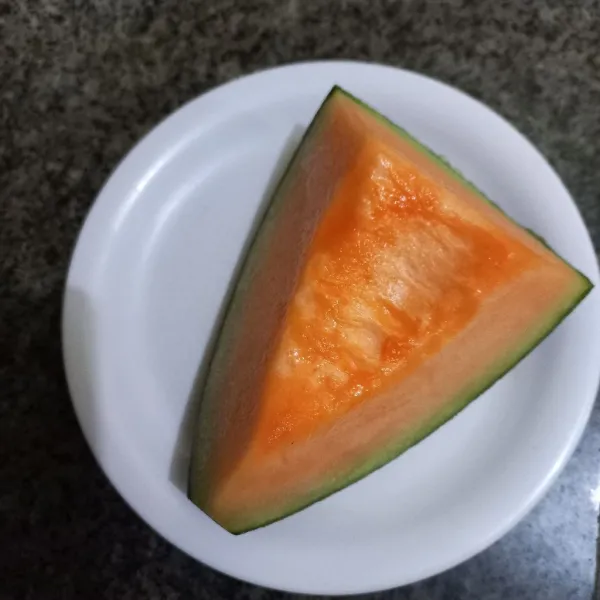 Siapkan potongan melon, kupas kulitnya.