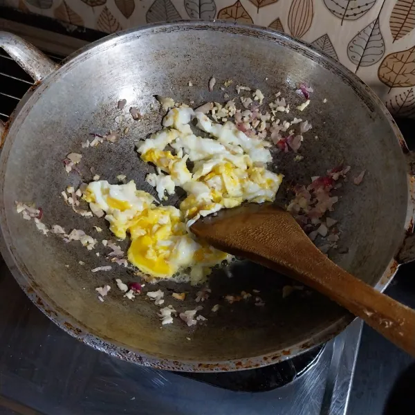 Panaskan minyak, tumis bawang merah dan bawang putih hingga layu. Tepikan. Masukkan telur, tunggu agak matang lalu orak-arik.