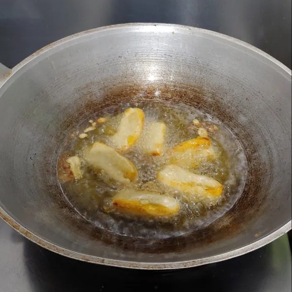 Panaskan minyak dalam api sedang lalu goreng pisang sampai kuning kecokelatan.