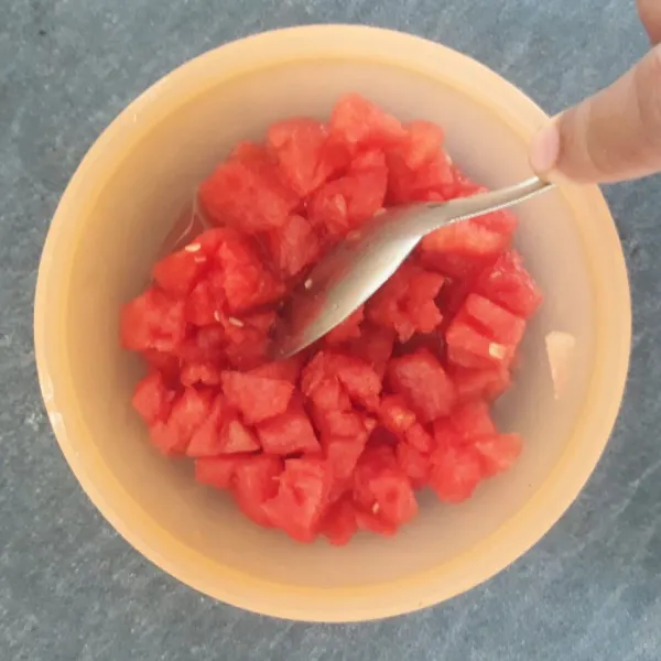 Cincang kasar semangka menggunakan sendok.
