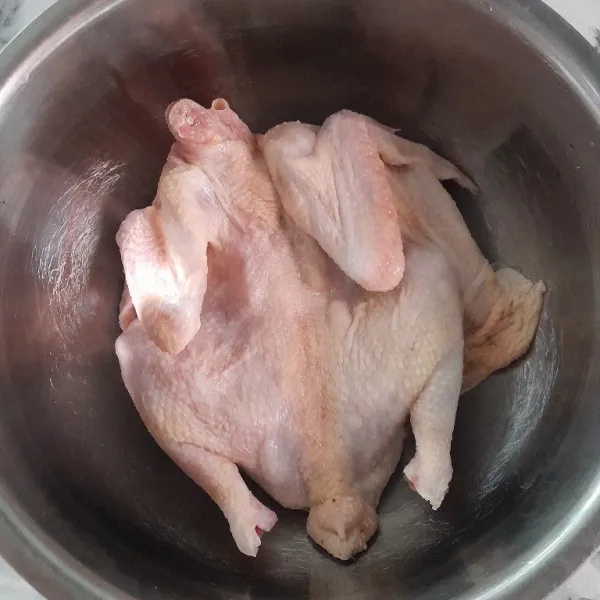 Siapkan ayam kampung, belah menjadi 2 bagian namun tidak putus.