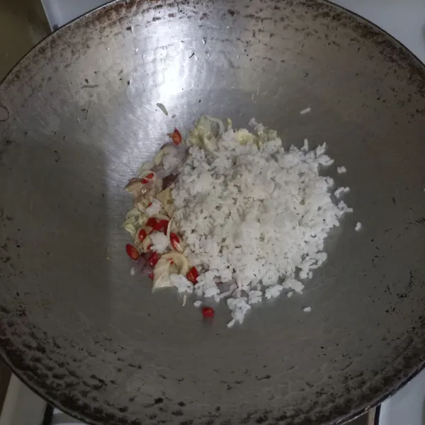 Masukkan nasi putih pada wajan, aduk rata