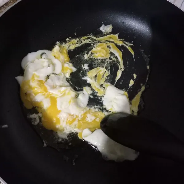 Goreng telur lalu acak pakai spatula.