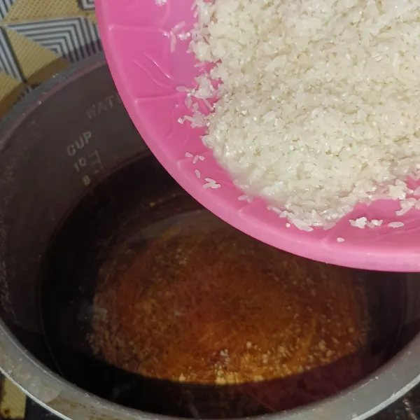 Cuci bersih beras, lalu masukkan beras dan air di panci.