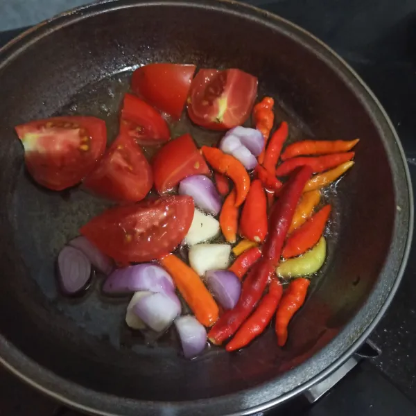 Goreng tomat, cabe rawit, cabe keriting, bawang merah dan bawang putih yang sudah diiris sebentar saja.