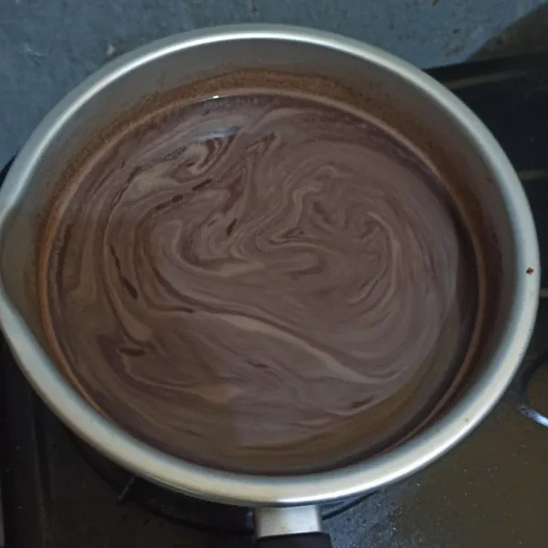 Beri susu cair cokelat dan air. Saring dan jangan sampai bergerindil. Atau bubuk cokelat dilarutkan dengan air panas terlebih dahulu. Kemudian masak hingga mendidih.