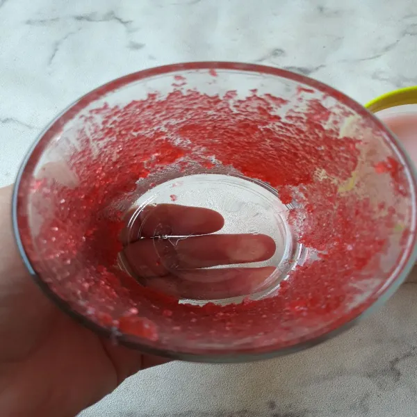 Oles selai strawberry di dalam gelas.