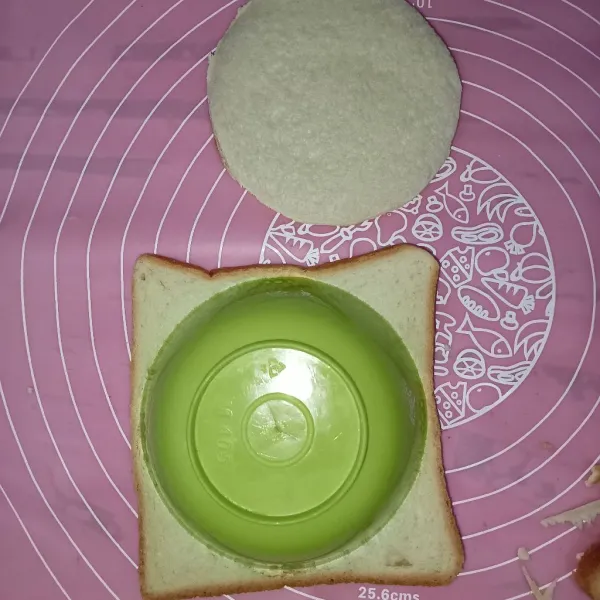 Potong roti berbentuk bulat menggunakan mangkuk tekan roti kemudian gunting pinggirannya.