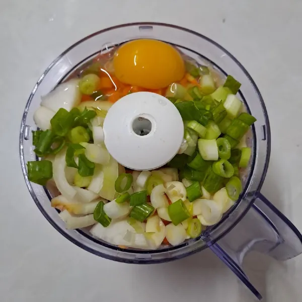 Tambahkan wortel, bawang bombay, bawang putih, daun bawang dan telur. Nyalakan food processor kembali sampai halus.