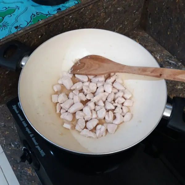 Panaskan minyak goreng, tumis bawang putih hingga harum, masukkan daging ayam, aduk-aduk sebentar.
