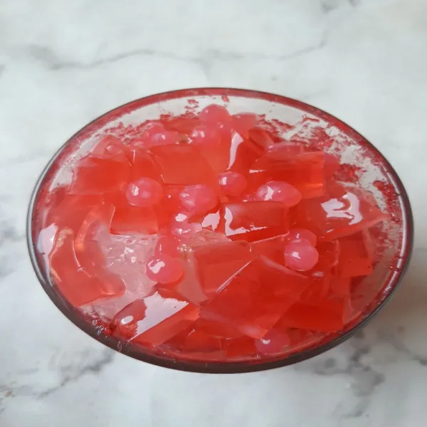 Masukkan jelly strawberry dan sagu mutiara.