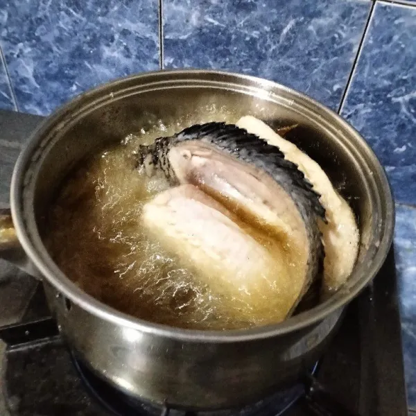 Másukkan agak banyak minyak goreng ke dalam panci. Sebaiknya gunakan panci anti lengket atau stainles steel. Setelah panas, masukkan ikan dengan posisi kedua daging yang disayat melebar di kedua sisi.