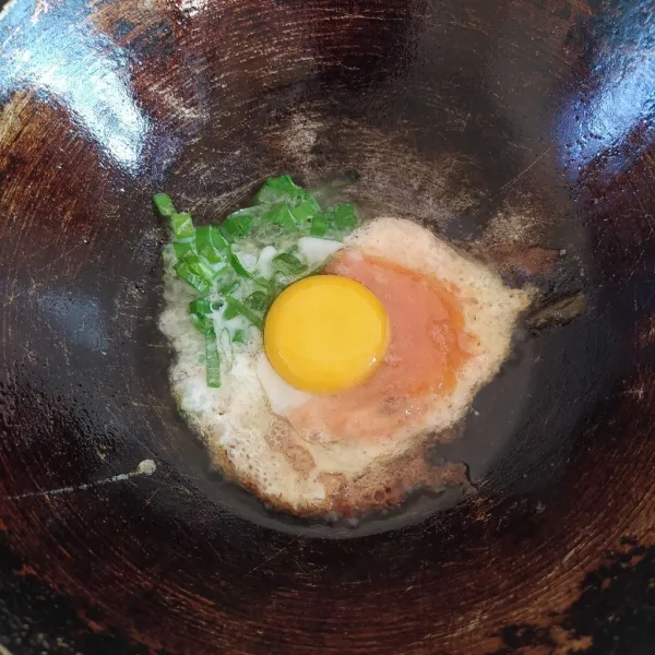 Panaskan minyak, tuangkan campuran putih telur secara bersamaan. Masukkan kuning telur di bagian tengah. Gunakan api sedang.