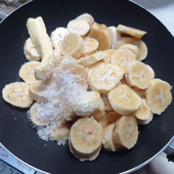 Potong-potong pisang dan masukan ke dalam teflon, lalu beri gula dan margarin.