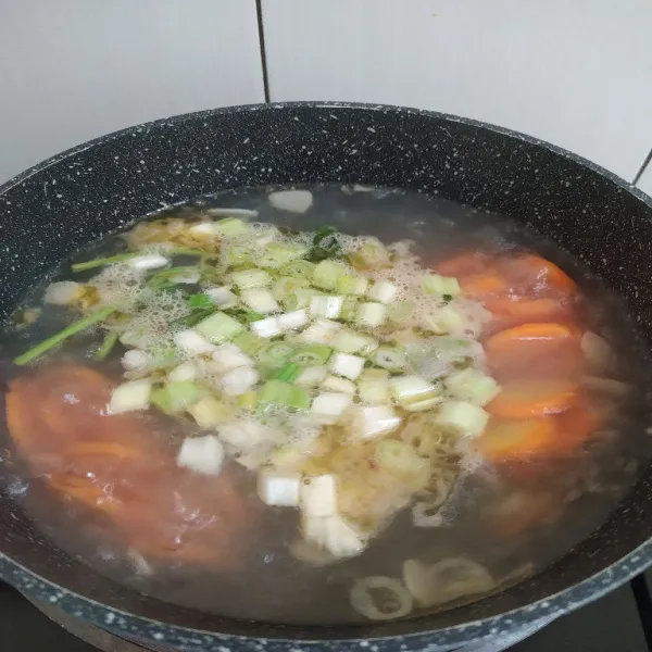 Masukkan air kaldu ayam, seledri, dan daun bawang.
