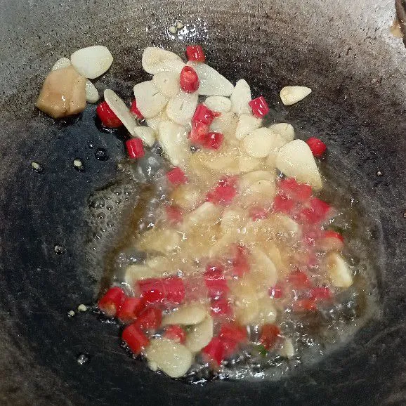 Tumis bawang putih, cabai, dan jahe sampai harum dan layu.