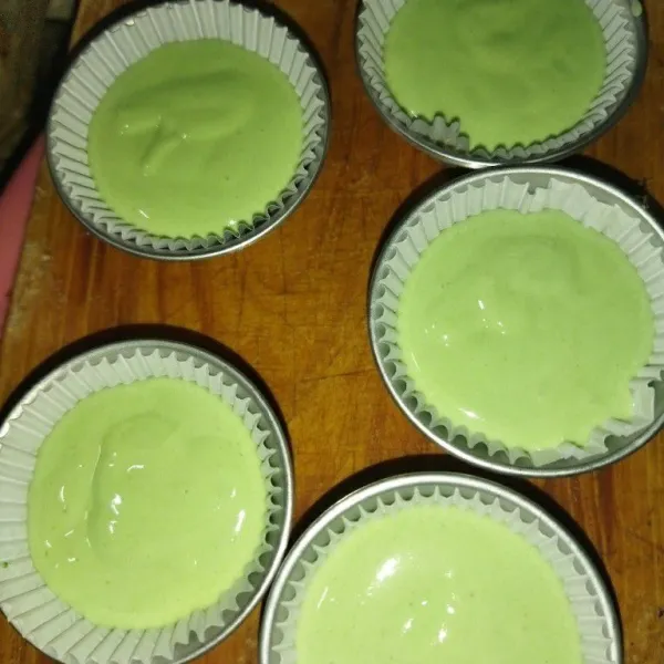 Siapkan cetakan bolu kukus yang tingginya sekitar 5 cm, alasi kertas cup, lalu tuang adonan hijau.