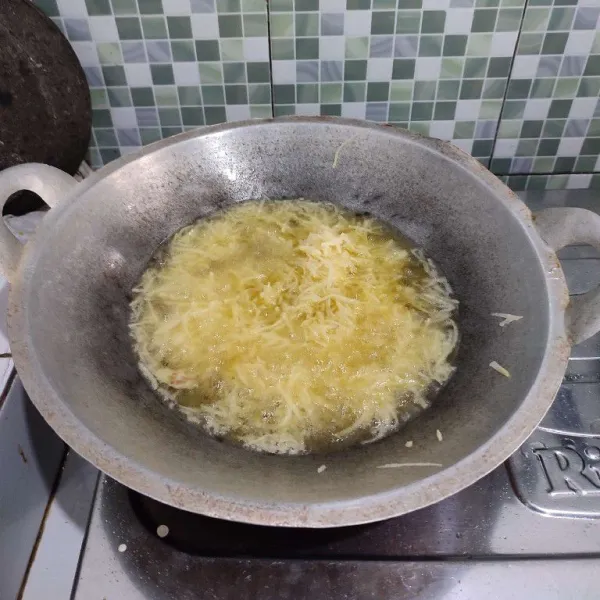 Tiriskan kentang secukupnya, lalu goreng dalam minyak panas dengan api sedang cenderung kecil. Jangan memasukkan kentang terlalu banyak agar tidak lengket.