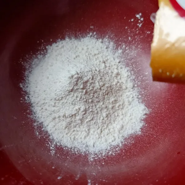 Masukkan tepung pisang goreng ke dalam suatu wadah, tambahkan gula pasir.