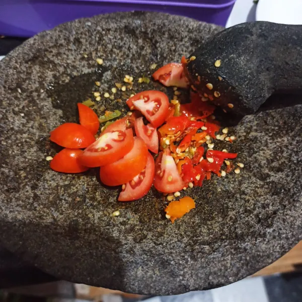 Ulek kasar cabe rawit, kemudian ulek tomat yang sudah diiris.
