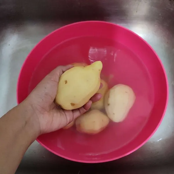 Kupas kulit kentang, kemudian cuci hingga bersih.